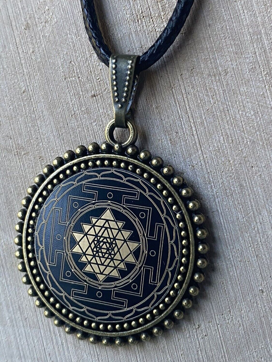 Amulett – Sri Yantra als nachtschwarzer 25 mm – Sri Yantra – 25 mm / goldlegiert / Fassung bronzefarben – Produktansicht 1