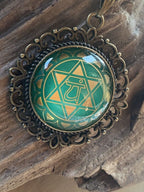 Amulett Chakremy – bronzefarben, Herzchakra, Disc hinter Glas in grün 25 mm, goldlegiert, kupferunterlegt – Produktansicht 1