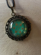 Amulett Chakremy – bronzefarben, Herzchakra, Disc hinter Glas in grün 25 mm, goldlegiert, kupferunterlegt – Produktansicht 1