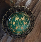 Amulett Chakremy – bronzefarben, Herzchakra, Disc hinter Glas in grün 25 mm, goldlegiert, kupferunterlegt – Produktansicht 1