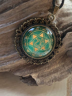 Amulett Chakremy – bronzefarben, Herzchakra, Disc hinter Glas in grün 25 mm, goldlegiert, kupferunterlegt – Produktansicht 1