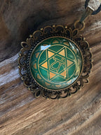 Amulett Chakremy – bronzefarben, Herzchakra, Disc hinter Glas in grün 25 mm, goldlegiert, kupferunterlegt – Produktansicht 1