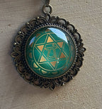 Amulett Chakremy – bronzefarben, Herzchakra, Disc hinter Glas in grün 25 mm, goldlegiert, kupferunterlegt – Produktansicht 1