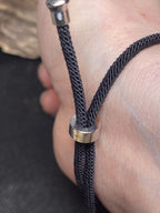 Armband-Kordel, schwarz , Symbol Lakhovsky MWO Schwingkreis Oszillator Antenne (stromlos), schwarze Disc gold legiert + Kupfer unterlegt ca. 25 mm hinter Glas,stufenlos durch Ziehen verstellbar