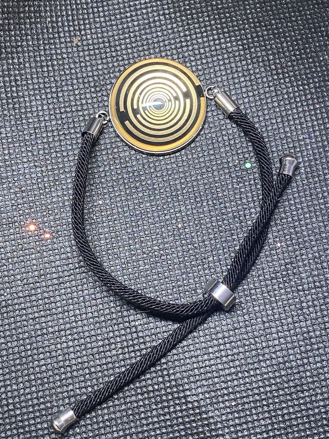 Armband-Kordel, schwarz , Symbol Lakhovsky MWO Schwingkreis Oszillator Antenne (stromlos), schwarze Disc gold legiert + Kupfer unterlegt ca. 25 mm hinter Glas,stufenlos durch Ziehen verstellbar