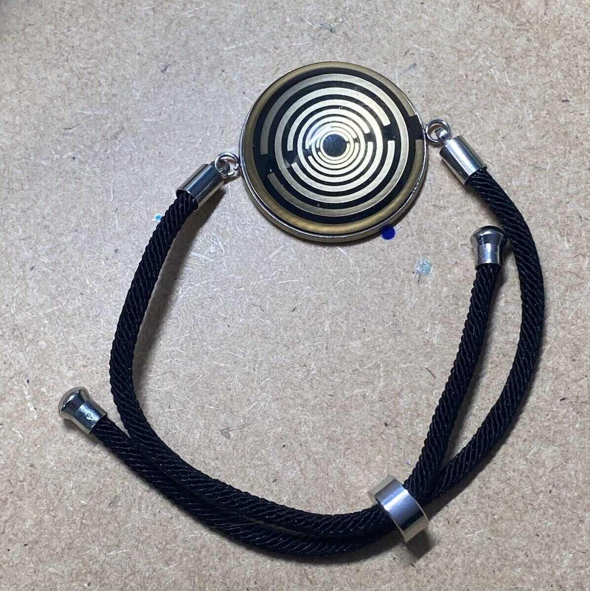Armband-Kordel, schwarz , Symbol Lakhovsky MWO Schwingkreis Oszillator Antenne (stromlos), schwarze Disc gold legiert + Kupfer unterlegt ca. 25 mm hinter Glas,stufenlos durch Ziehen verstellbar
