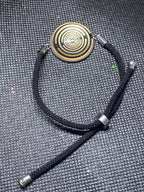 Armband-Kordel, schwarz , Symbol Lakhovsky MWO Schwingkreis Oszillator Antenne (stromlos), schwarze Disc gold legiert + Kupfer unterlegt ca. 25 mm hinter Glas,stufenlos durch Ziehen verstellbar