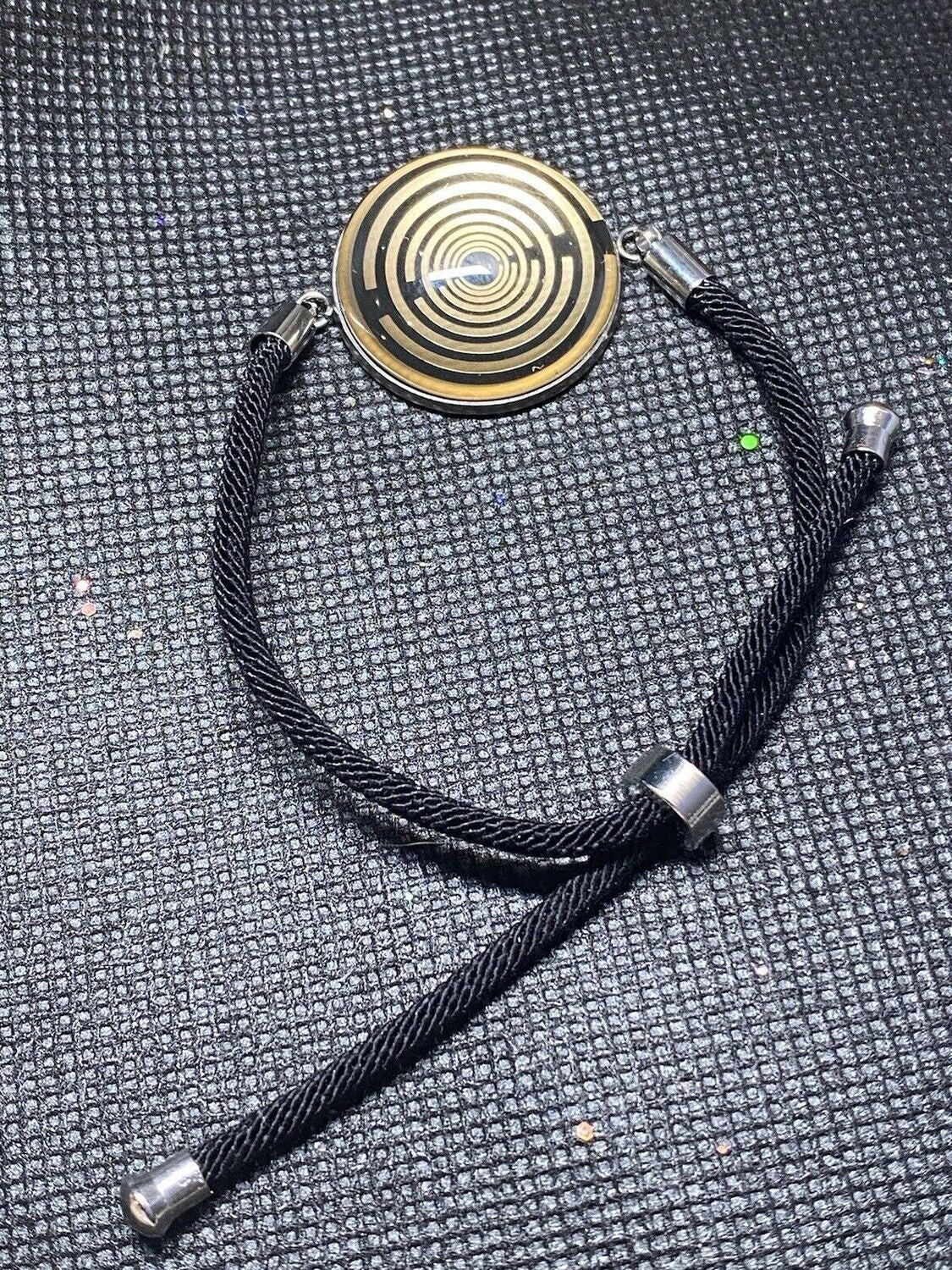 Armband-Kordel, schwarz , Symbol Lakhovsky MWO Schwingkreis Oszillator Antenne (stromlos), schwarze Disc gold legiert + Kupfer unterlegt ca. 25 mm hinter Glas,stufenlos durch Ziehen verstellbar