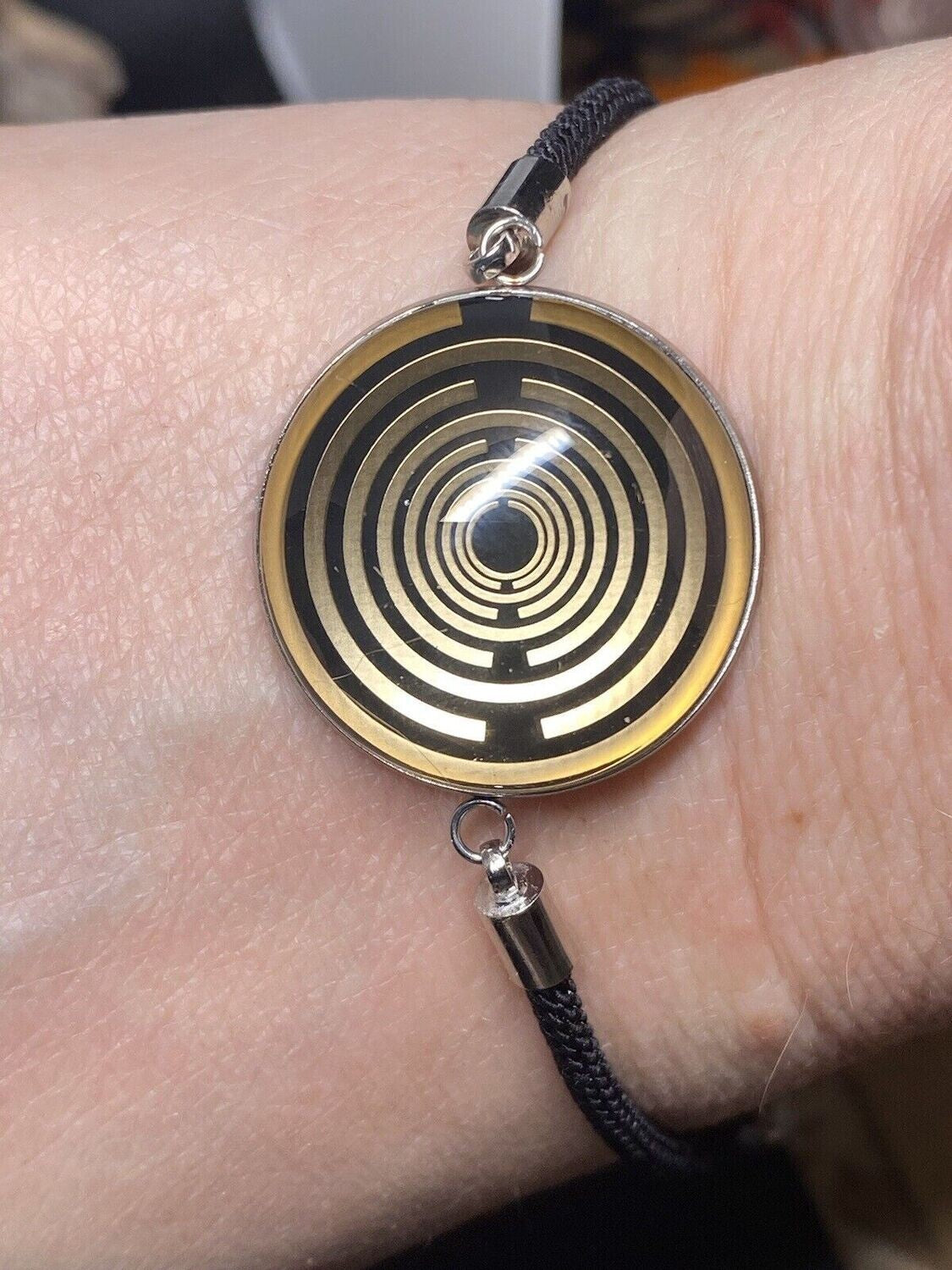 Armband-Kordel, schwarz , Symbol Lakhovsky MWO Schwingkreis Oszillator Antenne (stromlos), schwarze Disc gold legiert + Kupfer unterlegt ca. 25 mm hinter Glas,stufenlos durch Ziehen verstellbar