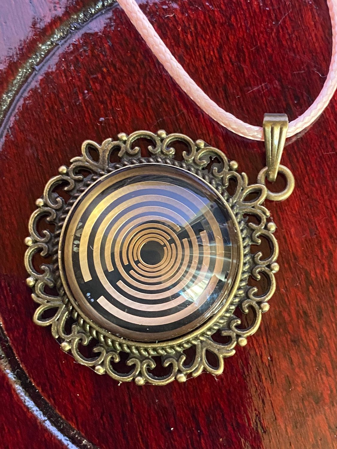 Amulett – bronzefarben, Lakhovsky MWOn Symbol, Disc in schwarz 25 mm, goldlegiert, kupferunterlegt – Produktansicht 1