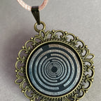 Amulett – bronzefarben, Lakhovsky MWOn Symbol, Disc in schwarz 25 mm, zinnlegiert, kupferunterlegt – Produktansicht 1
