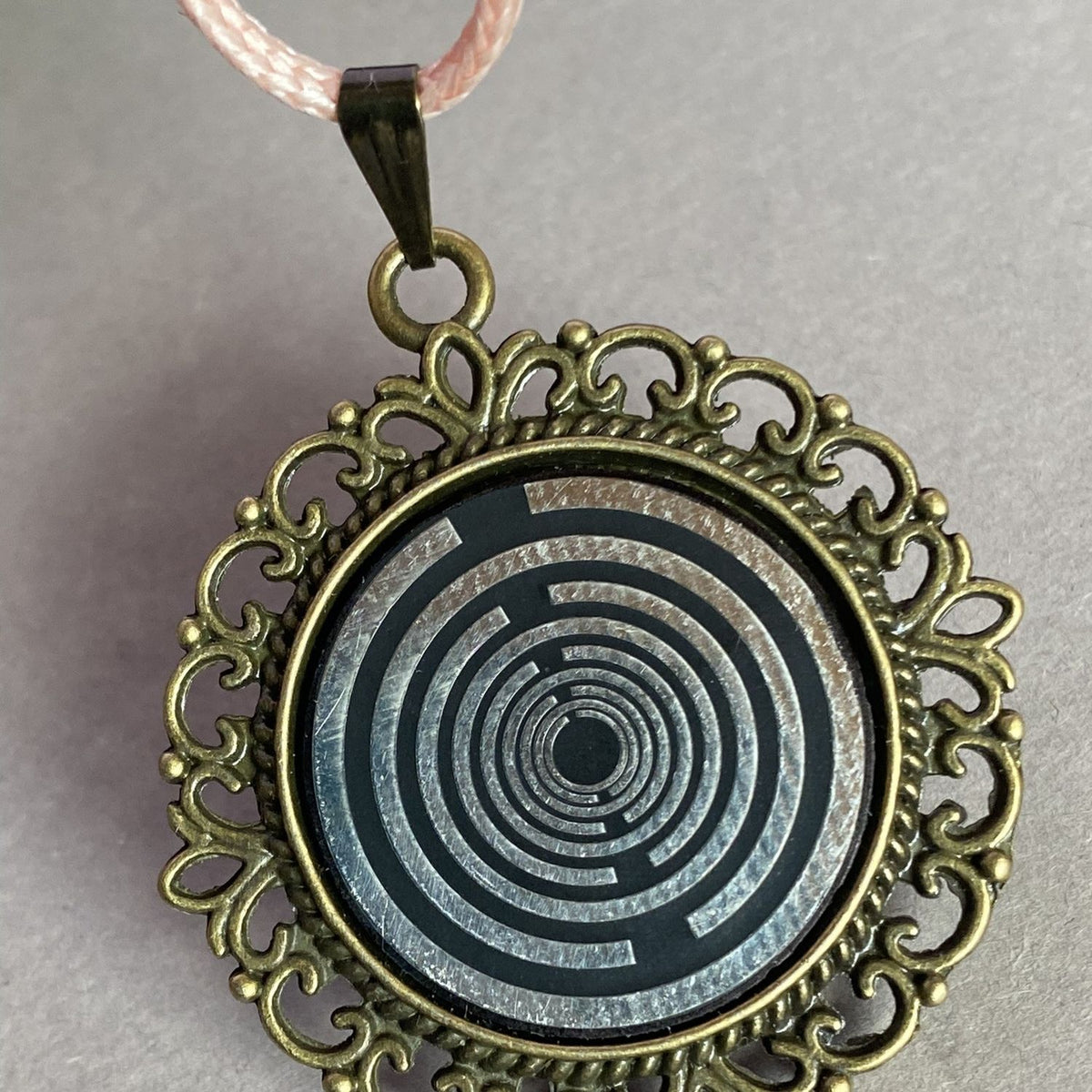 Amulett – bronzefarben, Lakhovsky MWOn Symbol, Disc in schwarz 25 mm, zinnlegiert, kupferunterlegt – Produktansicht 1