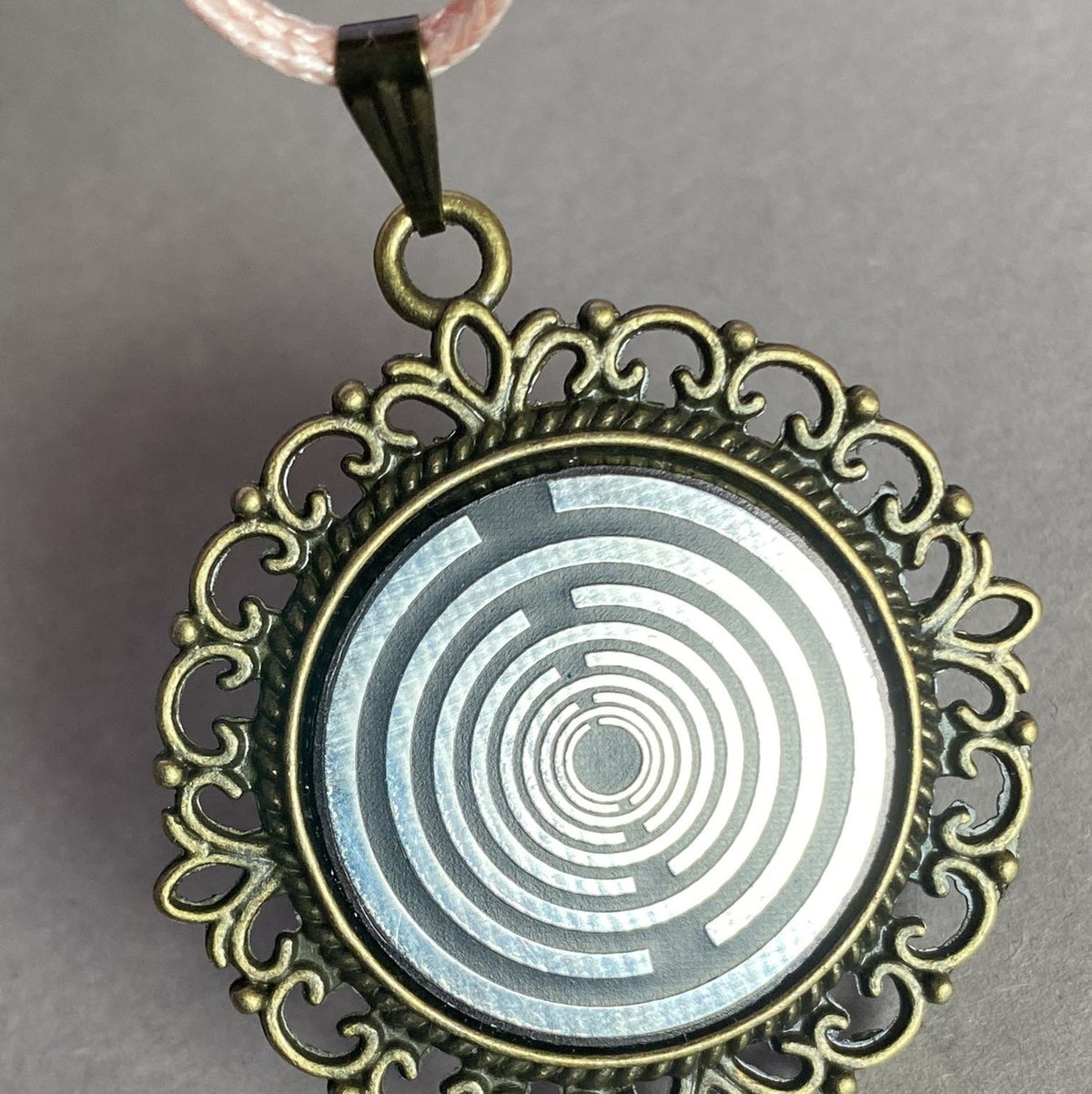 Amulett – bronzefarben, Lakhovsky MWOn Symbol, Disc in schwarz 25 mm, zinnlegiert, kupferunterlegt – Produktansicht 1