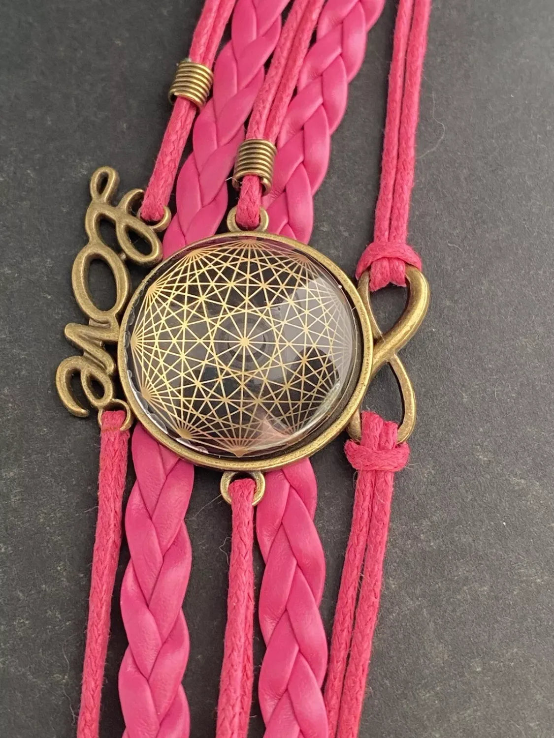 Armband - Dodecagram als nachtschwarzer ca. 25 mm großer Coin (hinter Glas) mit Goldlegierung in pinkes mehrsträngiges Band eingearbeitet