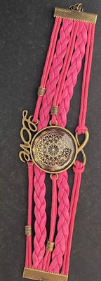 Armband - Dodecagram als nachtschwarzer ca. 25 mm großer Coin (hinter Glas) mit Goldlegierung in pinkes mehrsträngiges Band eingearbeitet