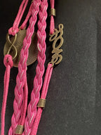 Armband - Dodecagram als nachtschwarzer ca. 25 mm großer Coin (hinter Glas) mit Goldlegierung in pinkes mehrsträngiges Band eingearbeitet