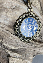 Amulett – Chakremy – bronzefarben, 3. Auge Disc in blau 25 mm, goldlegiert, kupferunterlegt – Produktansicht 1
