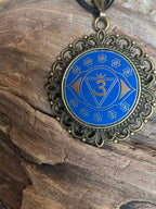 Amulett – Chakremy – bronzefarben, 3. Auge Disc in blau 25 mm, goldlegiert, kupferunterlegt – Produktansicht 1